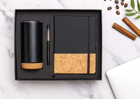 Black gift box with a cork-panel diary, slim pen and a tall black tumbler on a cork base