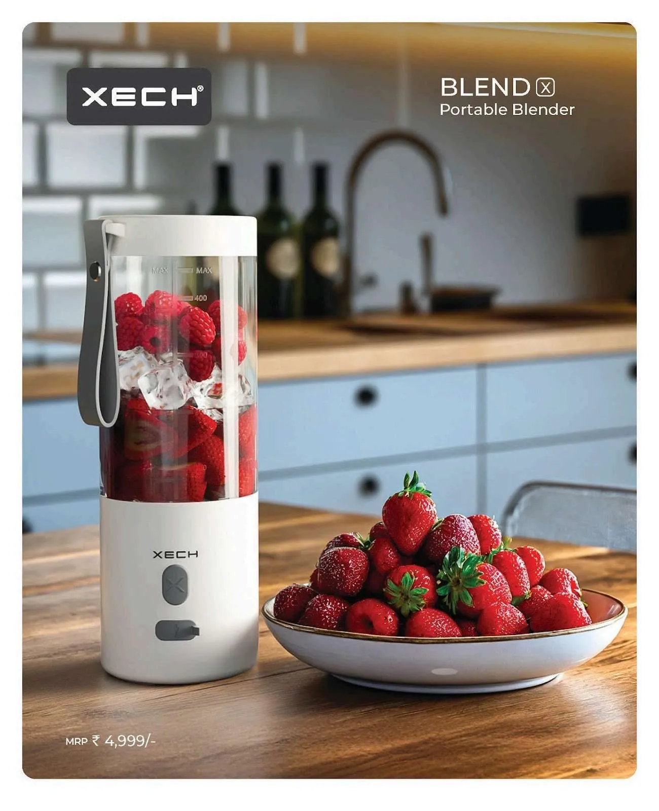 XECH BlendX white portable blender filled with strawberries, raspberries and ice on a kitchen counter beside a bowl of strawberries.