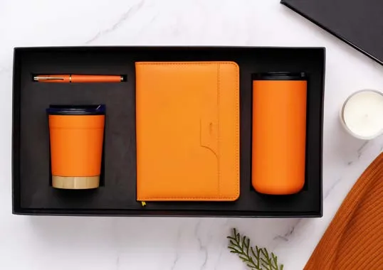 Orange cork-base coffee cup, orange diary, orange flask and orange pen set in a black gift tray.