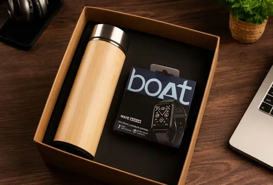 Bamboo flask beside a boAt smartwatch retail box inside a kraft gift box on a desk