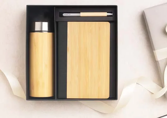 Black tray holding a bamboo flask with steel lid, a bamboo-cover diary and a pen