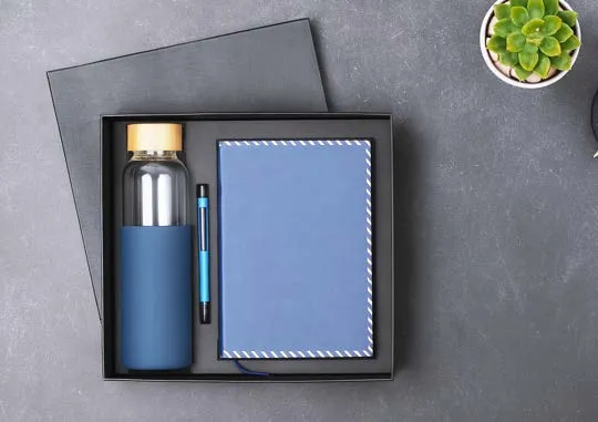 Blue gift box with bamboo-lid glass bottle, blue pen and a stitched-edge blue diary.