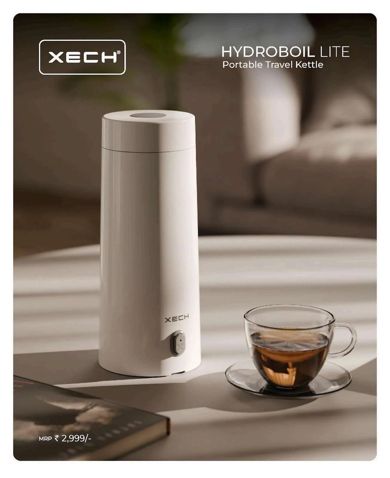XECH Hydroboil Lite slim white portable travel kettle on a table beside a glass cup of tea.