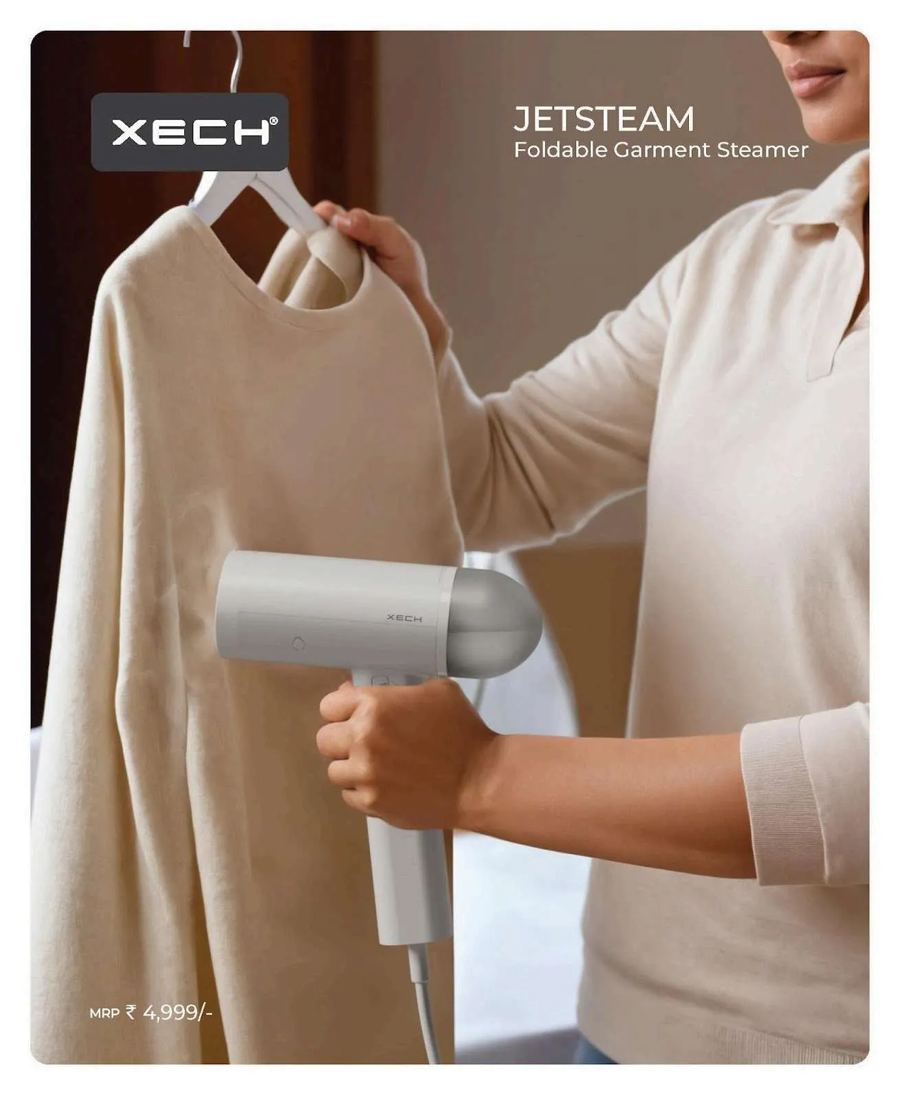 XECH JetSteam white foldable garment steamer being used on a beige sweater on a hanger.