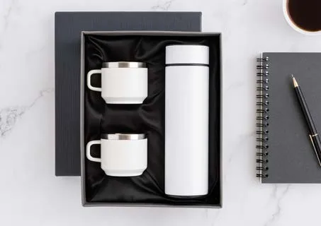 White vacuum flask, two white mugs, grey notebook and pen in a gift box labelled MonoBox