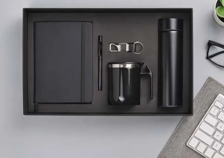 Black five-piece gift set with diary, pen, keychain, handled mug and temperature-display flask in a black tray.