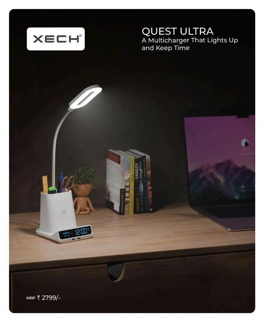 White XECH Quest Ultra desk station with a lit gooseneck LED lamp, pen holder and a blue 12:00 LED clock, beside books and a laptop.