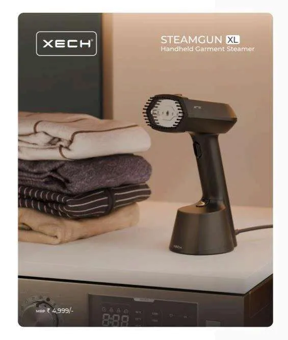 XECH Steam Gun XL bronze handheld garment steamer resting on its docking base beside folded knitwear.