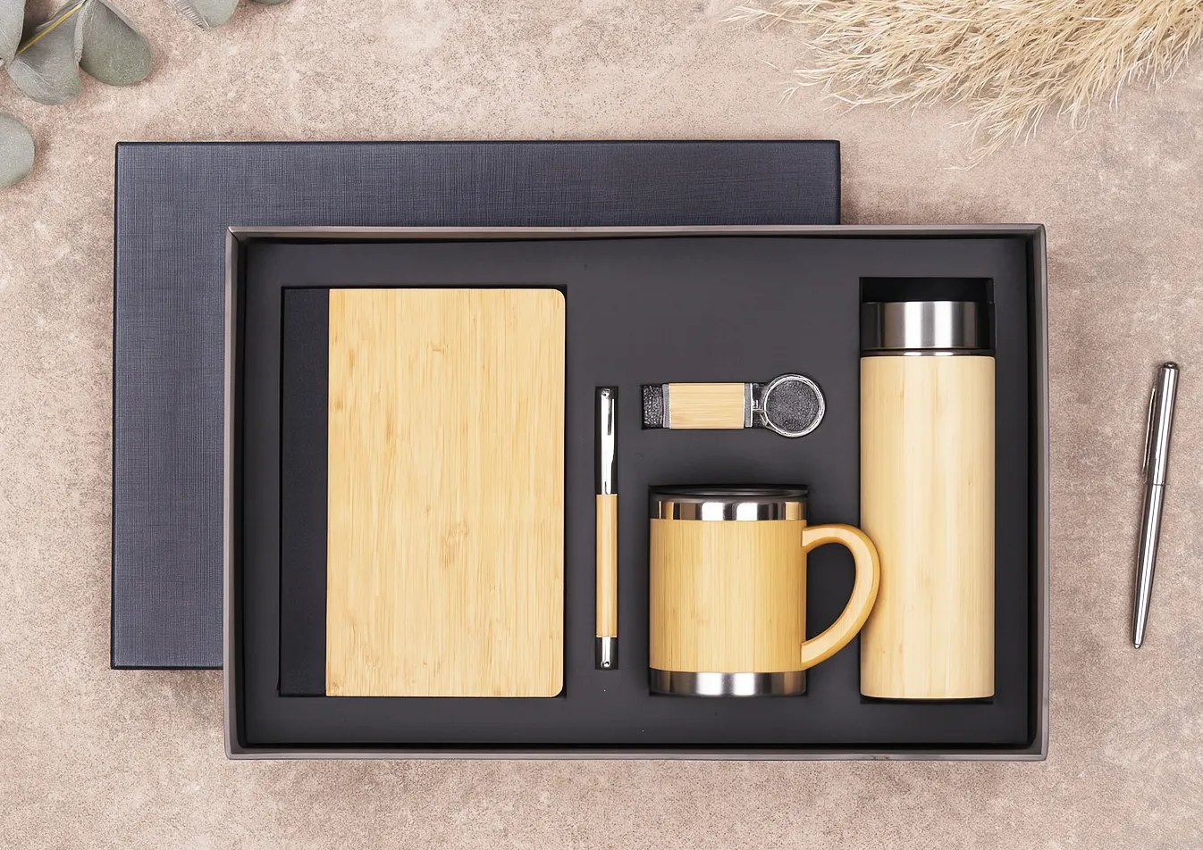 Bamboo-finish gift set with diary, pen, USB keychain, steel mug and vacuum flask in a black box.