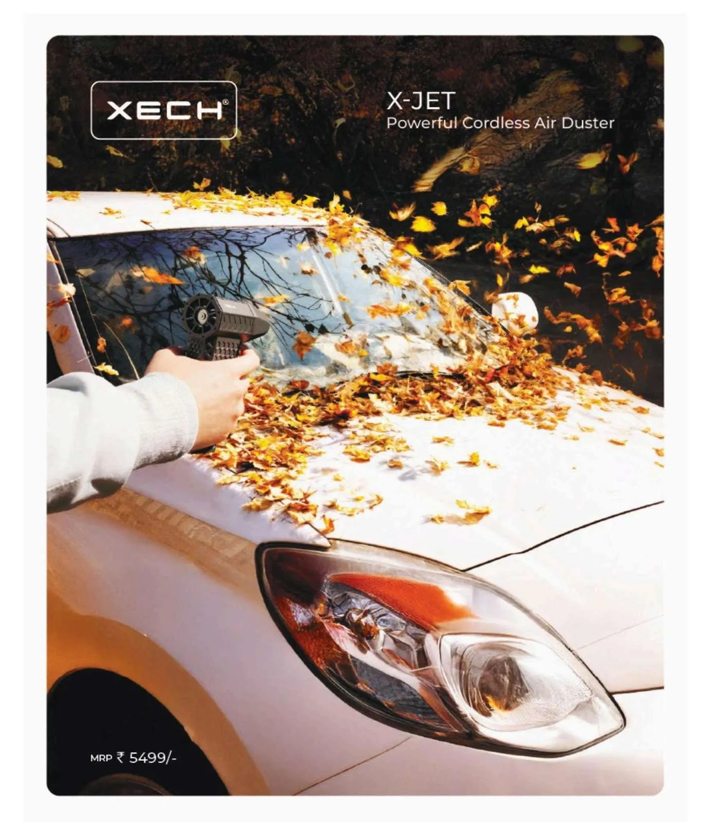 Hand using the XECH X-Jet cordless air duster to blow autumn leaves off the windscreen and bonnet of a white car.